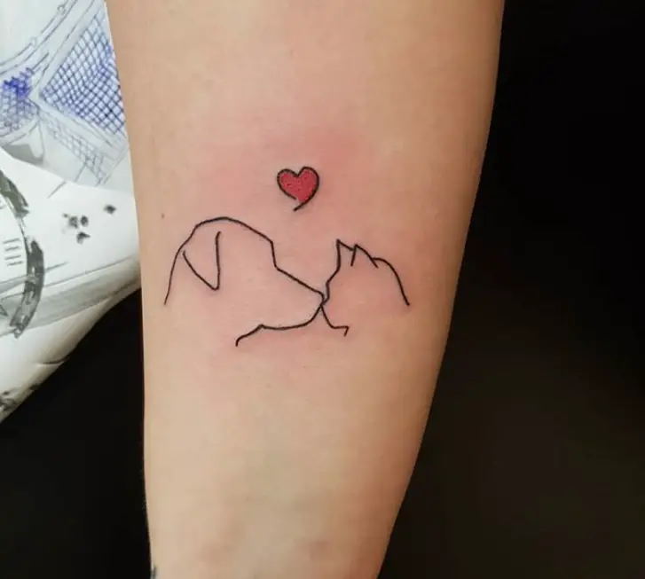 line tattoo of dog kissing a cat with a red heart on top on the arm