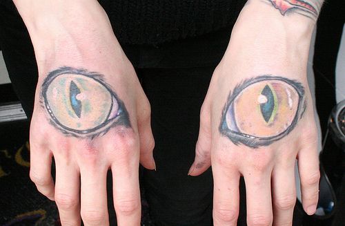 Cat Eye tattoo on both hands of a girl