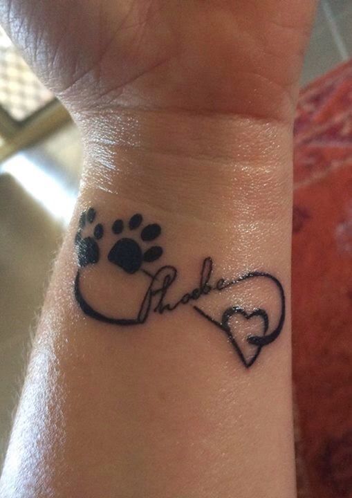 infinite sign with paw prints and heart, and name in the middle tattoo on wrist