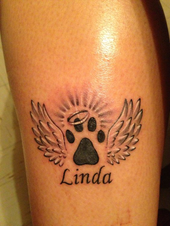 paw with angel wings, halo and name tattoo on wrist