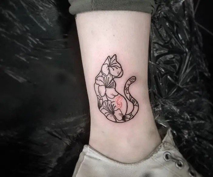 cat with flowers tattoo on the side of legs