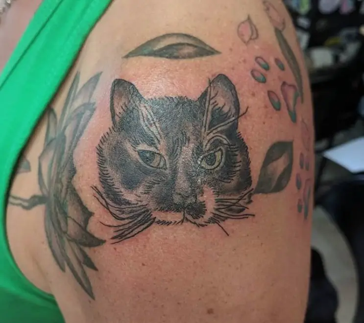 cat face with leaves around tattoo on shoulder