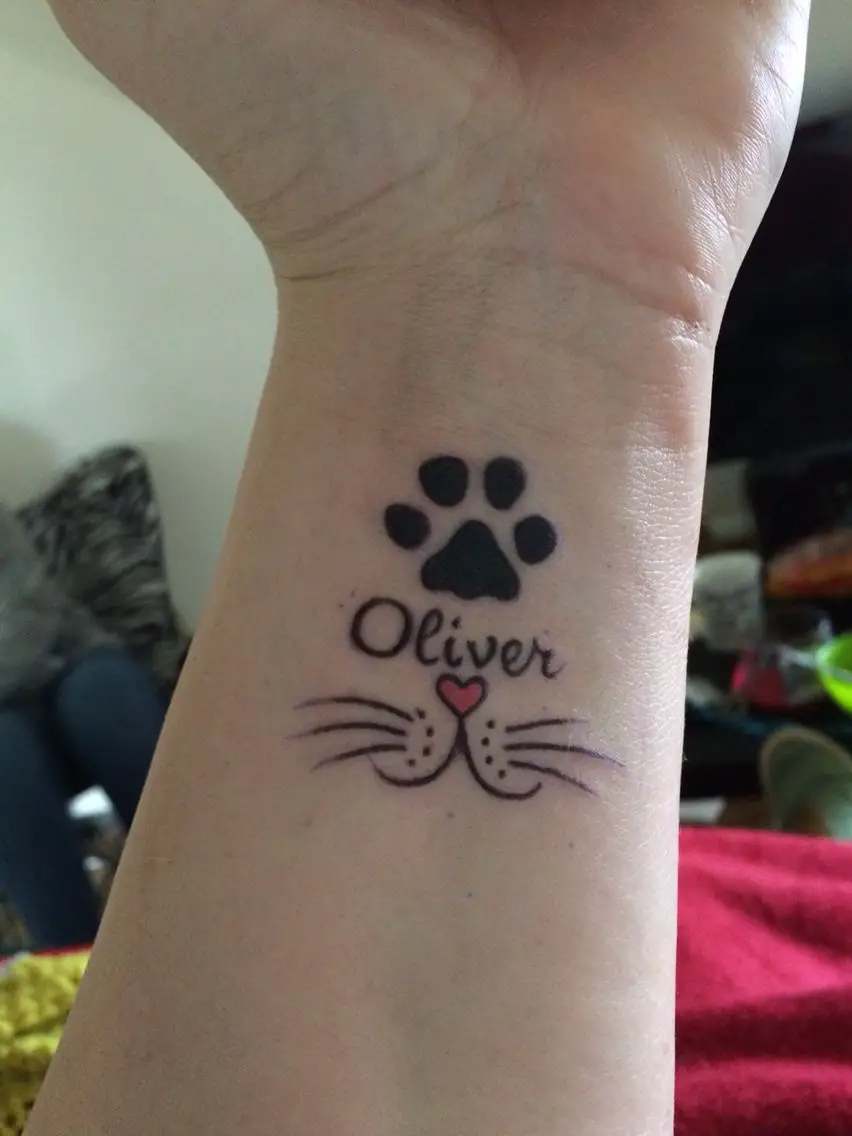 cat mouth and paws with name tattoo on wrist