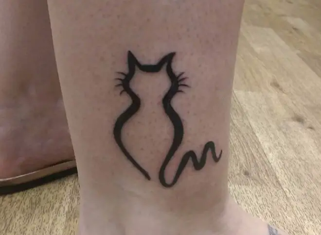 outline of a sitting cat tattoo on the ankle
