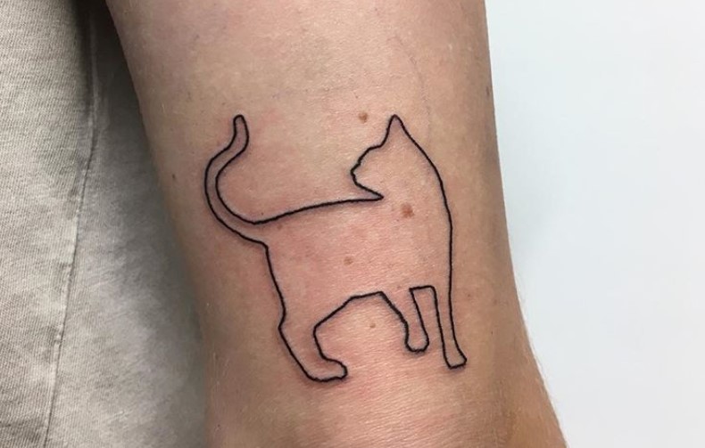 outline of a standing cat tattoo on the leg