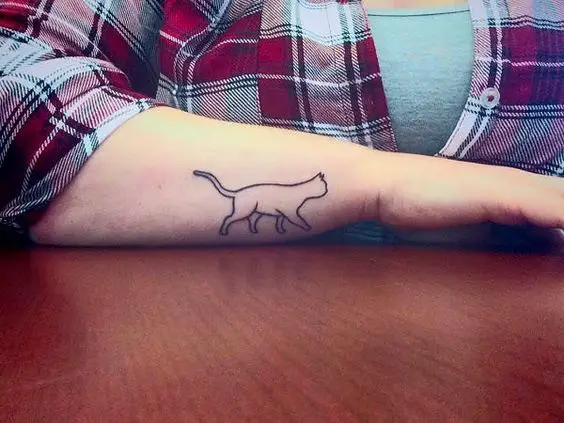 walking cat tattoo on the forearm