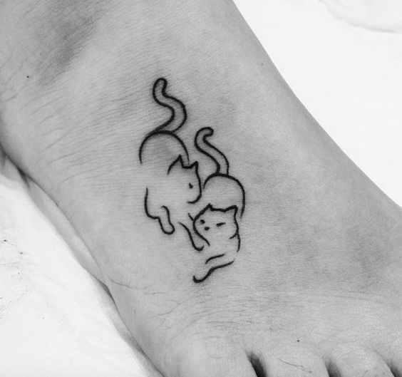 outlines of two cats tattoo on foot
