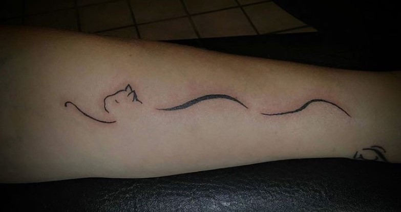 minimalist outline of a cat tattoo on the forearm