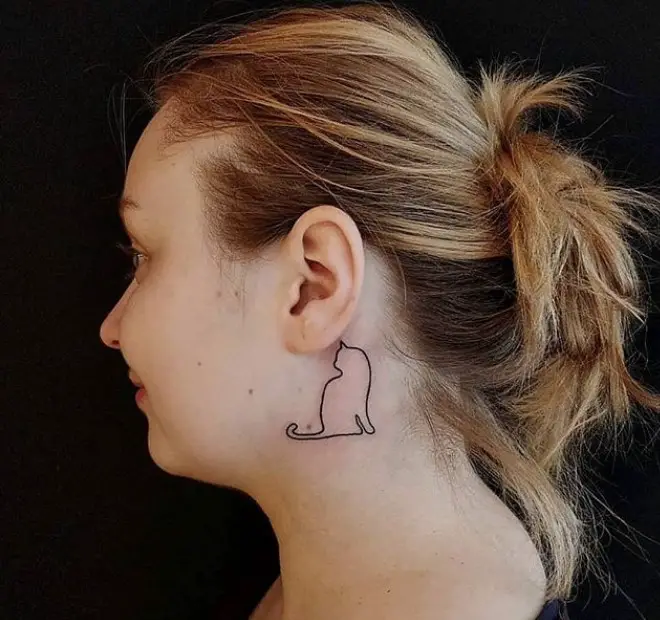 outline of a sitting cat tattoo behind the ear of a girl