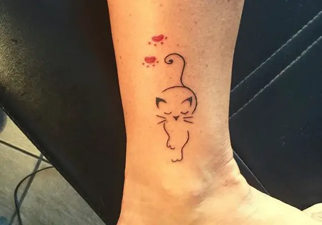 slick outline of a cat with red paw prints above tattoo on ankle