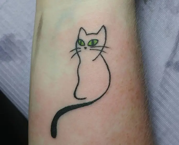 outline of a sitting cat with green eyes tattoo on the wrist