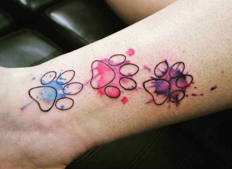 three outline of Cat Paw Prints with watercolors tattoo on the wrist