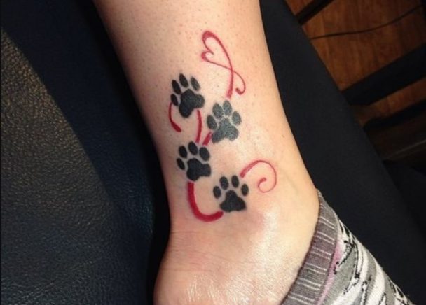 four black Cat Paw Prints with red curvy lines tattoo on the ankle