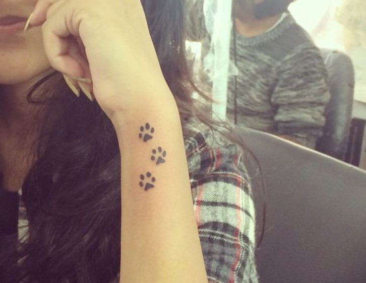 three small Cat Paw Prints tattoo on the side of the wrist