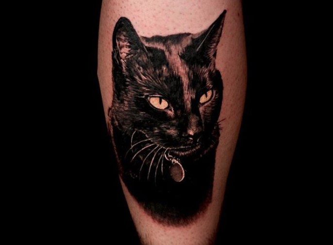 A realistic black Cat Portrait Tattoo on the leg