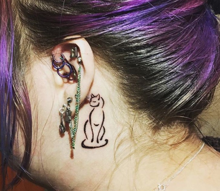 outline of a sitting cat while looking on her side tattoo behind the ears