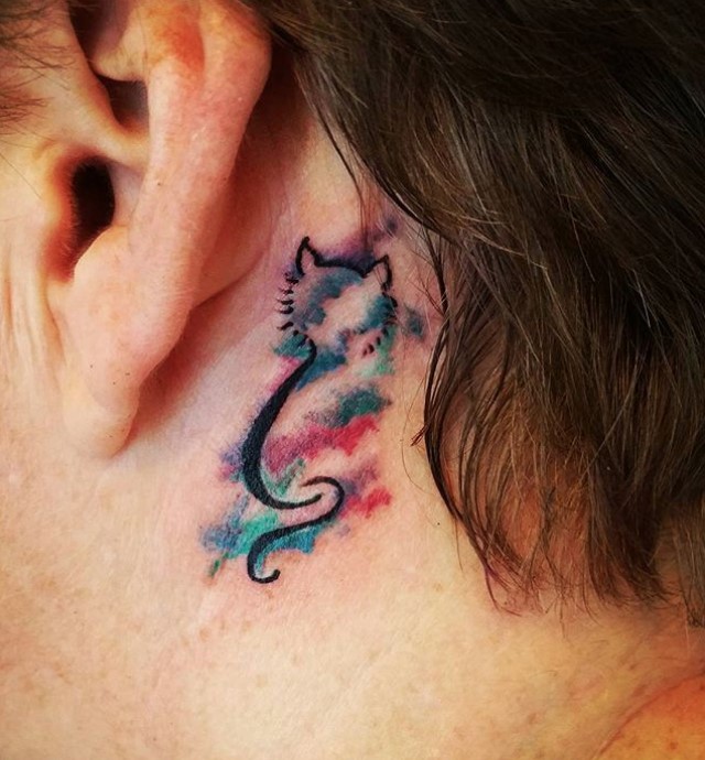 outline of a sitting Cat with splashes of galaxy watercolor tattoo behind the ears