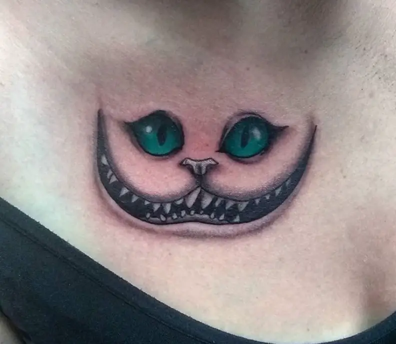 simple black and gray Cheshire Cat with green eyes tattoo on the chest