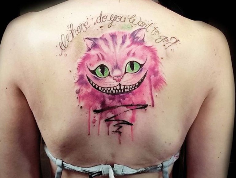 bright pink Cheshire Cat with green eyes and words