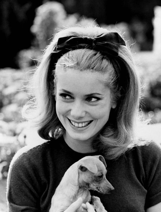 black white photo pg Catherine Deneuvesmiling with her Chihuahua