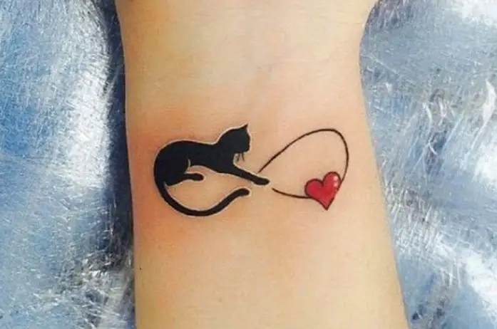 infinity sign with a cat and red heart tattoo on the wrist