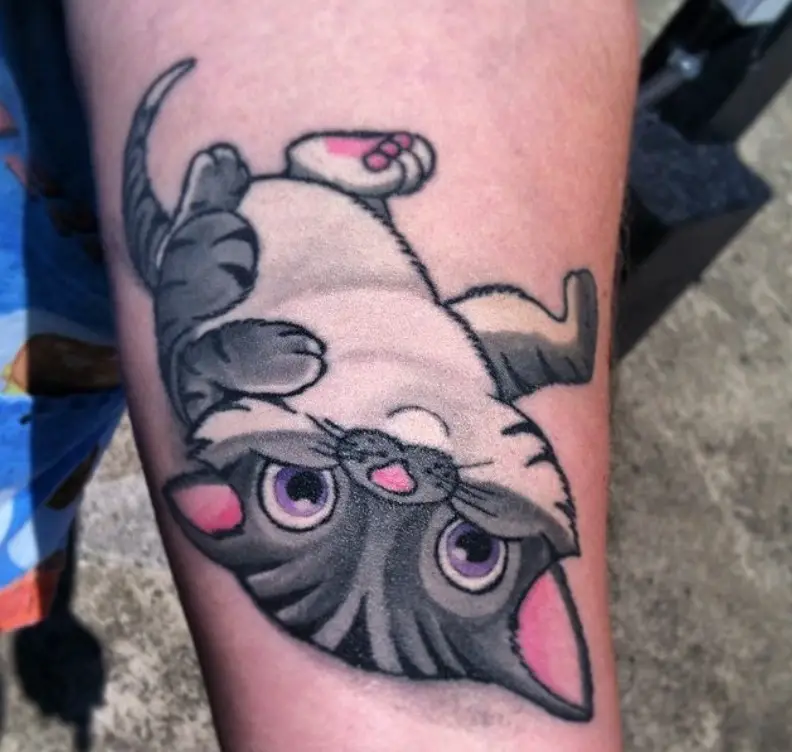 Animated lying on its back gray cat tattoo on the forearm