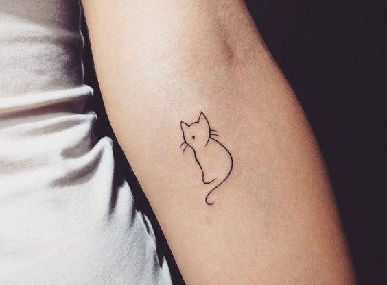 minimalist outline of a cat tattoo on the forearm