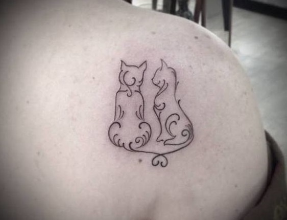 outline of two cats tattoo on the back