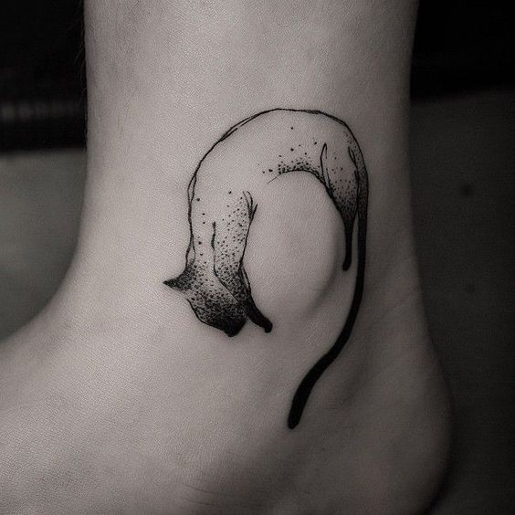 a hanging outline of a balck cat tattoo on the ankle