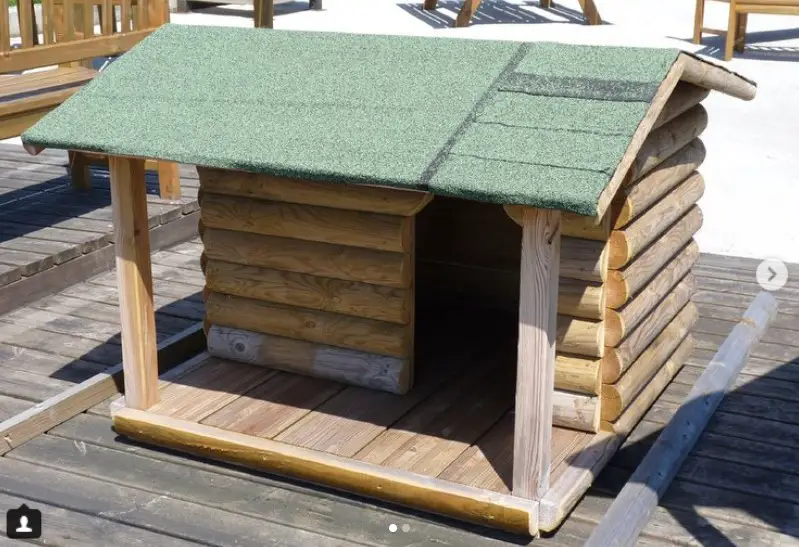 A modern dog house made of chopped wood trunk