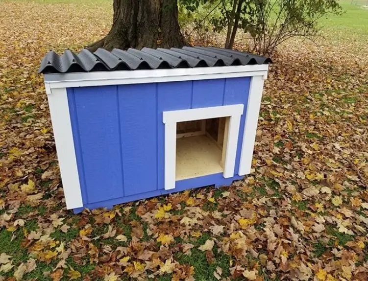A blue moden dog house with a roof 