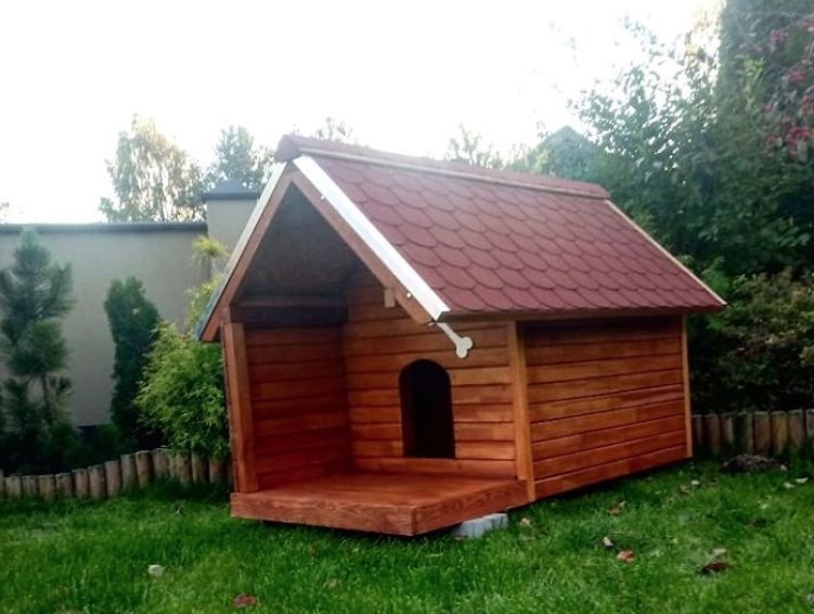 A large red wooden dog house in the backyard