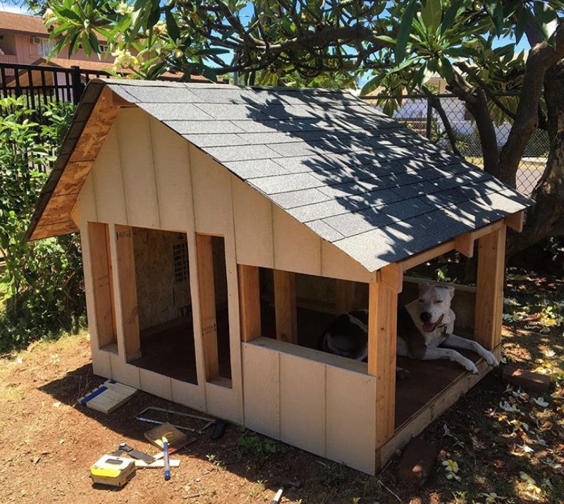 A large wooden dog house in the garden