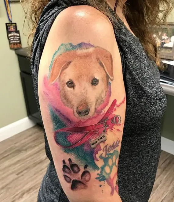 watercolor face of dog with collar and paw prints tattoo on the shoulder