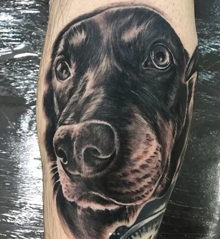 black dog's face tattoo on the leg