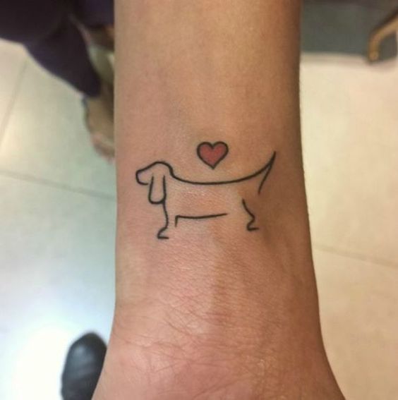 Dachshund putline with a red heart on top tattoo on the wrist
