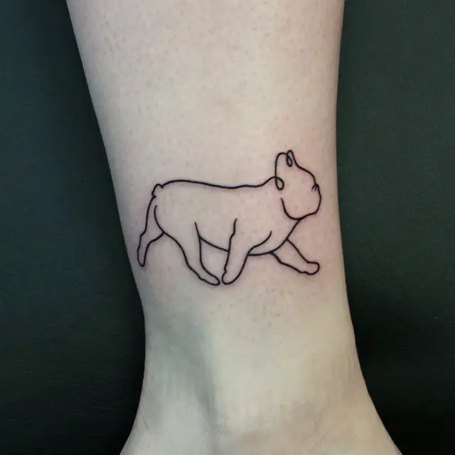 outline of a walking dog tattoo on the ankle