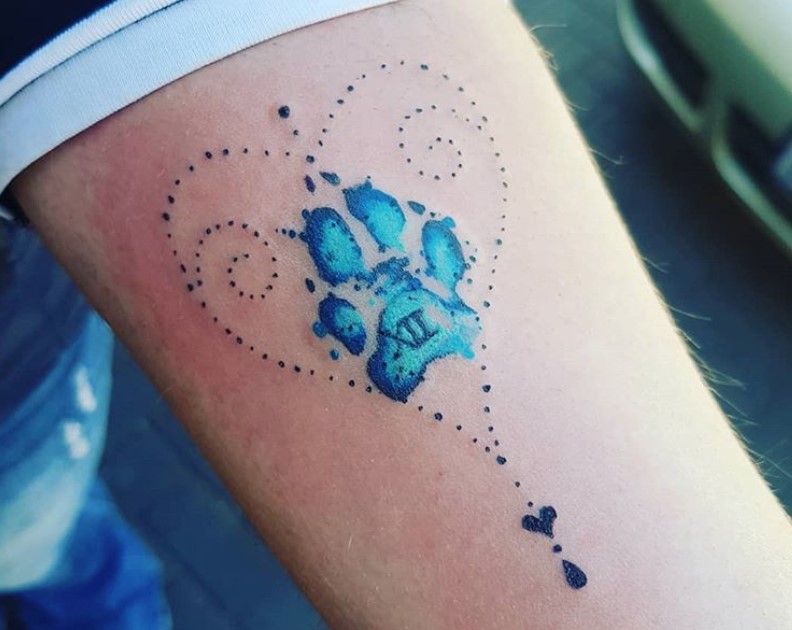 blue paw print in side a dotted heart shaped tattoo