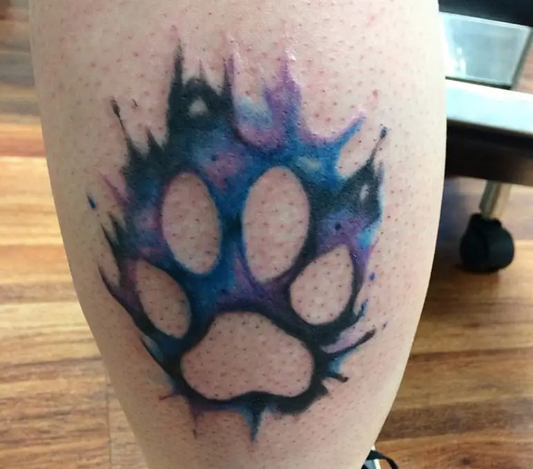 watercolor paw print tattoo on the leg