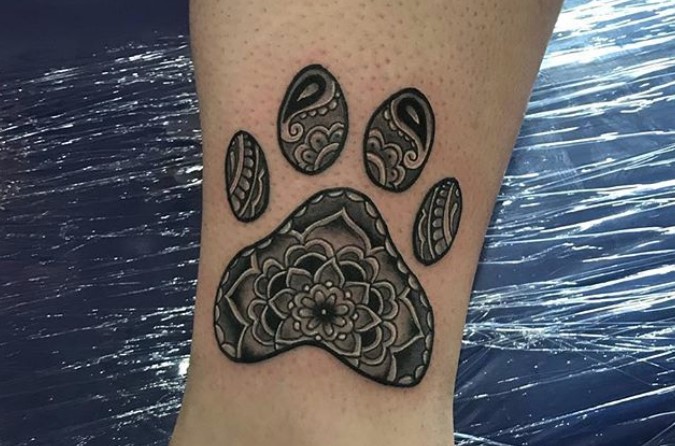 mandala design in paw print tattoo on the leg