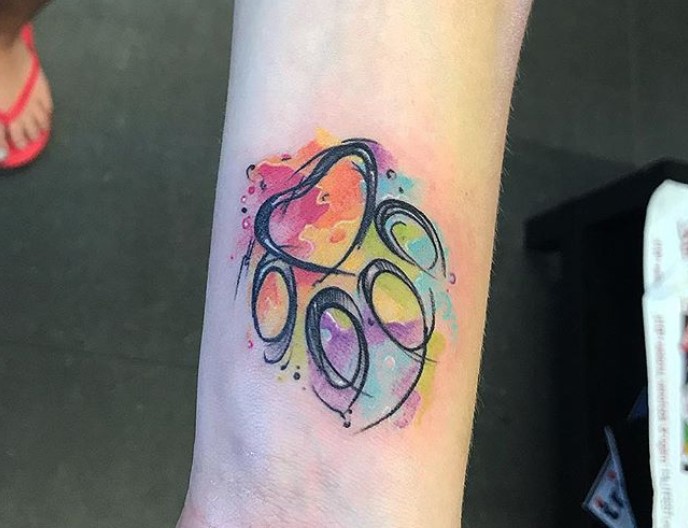 outline of paw print with colorful watercolor tattoo