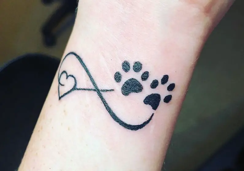 infinity sign with paw print and heart tattoo on wrist