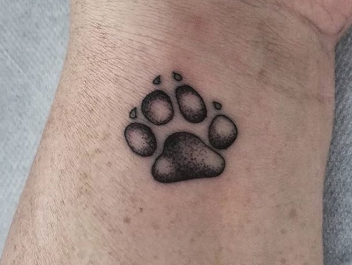 small paw print tattoo on the wrist