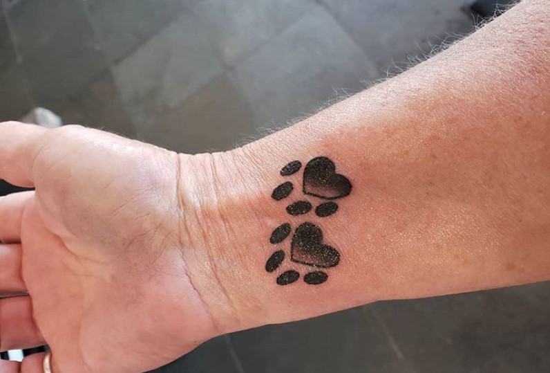 shaded paw print tattoo on wrist