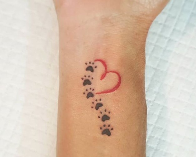 Heart with paw prints tattoo on wrist