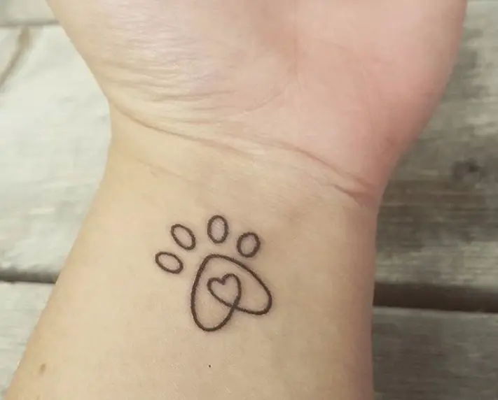 lined paw print tattoo on wrist