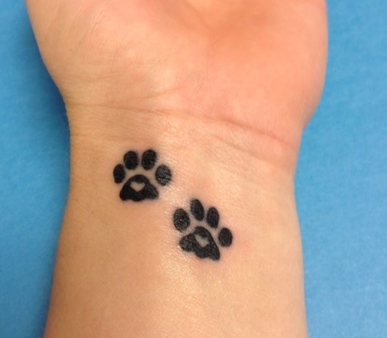 simple paw print tattoo on wrist