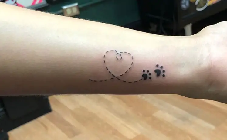 Heart dotted lines with paw prints tattoo on wrist