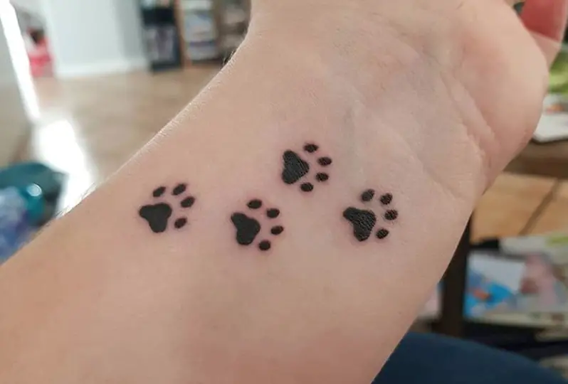 four paw prints tattoo on wrist