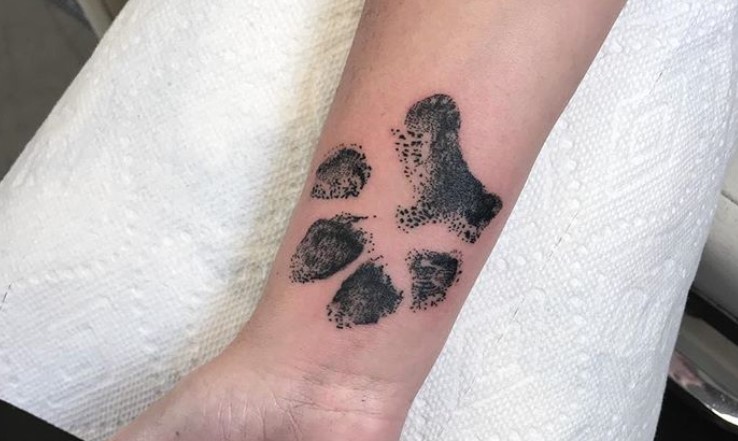 large paw print tattoo on wrist